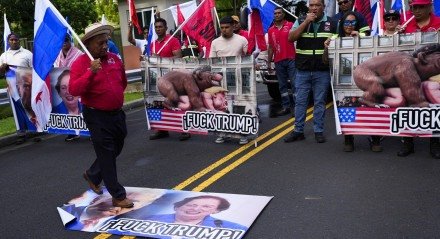 Um manifestante caminha sobre uma faixa com a imagem do presidente eleito dos EUA, Donald Trump, e da embaixadora dos EUA no PanamÃ¡, Mari Carmen Aponte, durante um protesto em frente Ã  embaixada dos EUA na Cidade do PanamÃ¡.