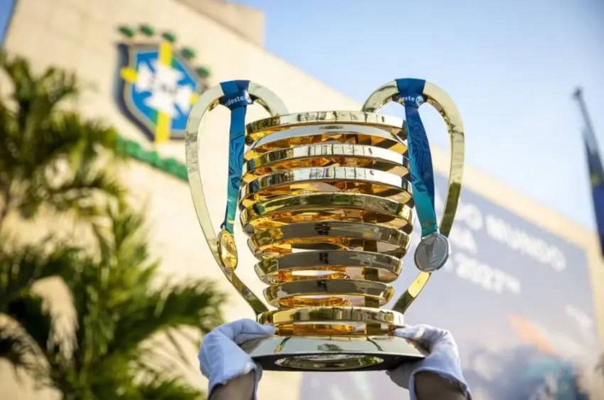 Taça da Copa do Nordeste em foto na frente da sede da CBF