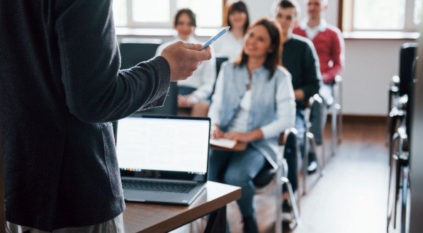 imagem ilustrativa de sala de aula com alunos e um professor
