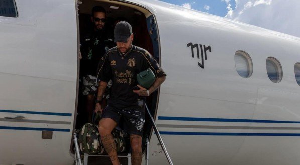 Neymar com a camisa do Santos saindo do avião particular