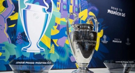 Taça da Champions League ao lado dos potes do sorteio