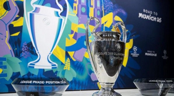 Taça da Champions League ao lado dos potes do sorteio