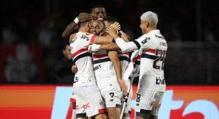 Lucas Moura abraçados por jogadores do São Paulo após gol