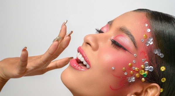 Woman wearing pink makeup and embellishments on her face. Isolated on white background