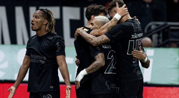 Jogadores do Corinthians abraçados comemorando vitória