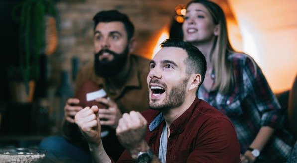 Imagem de pessoas assistindo partida de futebol