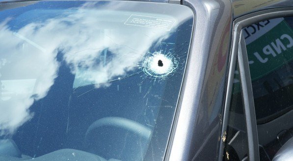 O carro do policial está com marcas de disparos no para-brisa