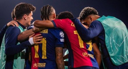 Jogadores do Barcelona abraçados em jogo da Champions League