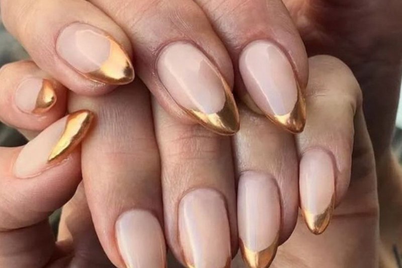 Desing dourado de unhas.