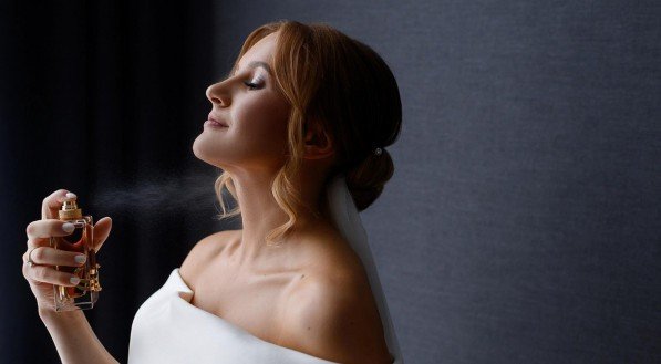 Imagem de mulher passando um perfume