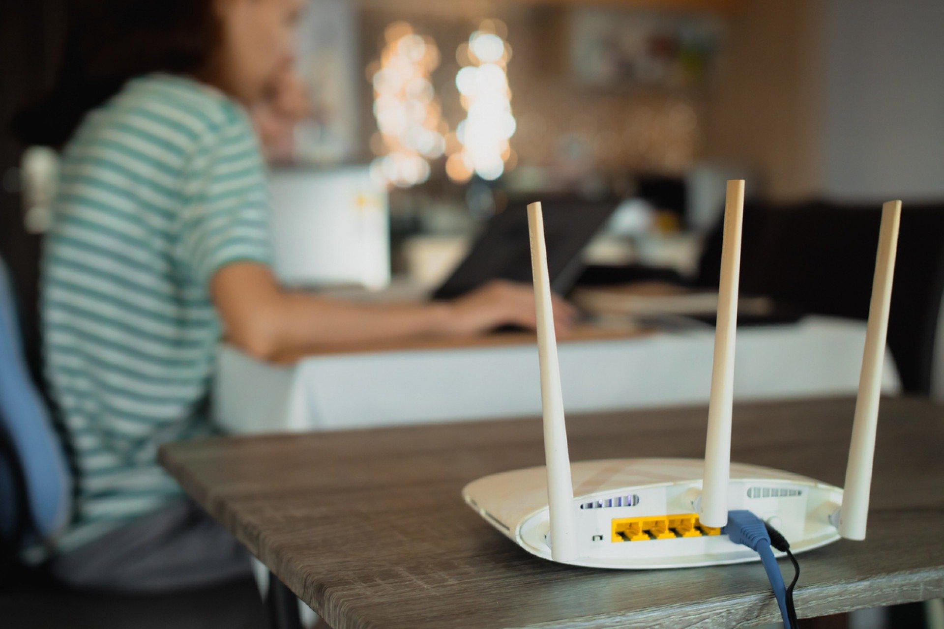 Imagem de uma mulher perto de um roteador wi-fi