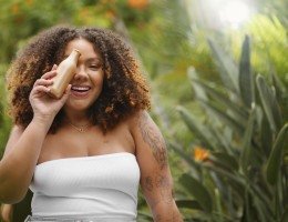 Imagem de uma mulher feliz segurando perfume