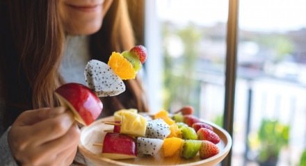 Imagem ilustrativa de uma mulher comendo frutas! 