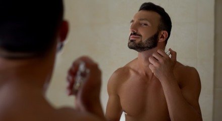 Homem se perfuma no banheiro