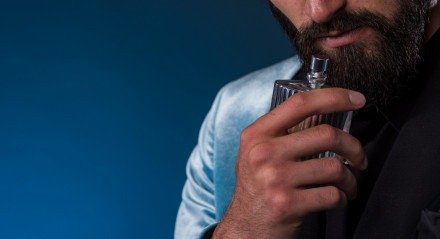 Homem segurando um frasco de perfume