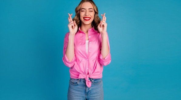 Imagem de uma mulher com dedos cruzados para representar esperança