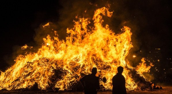 Imagem de uma fogueira em uma praia à noite