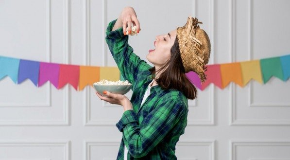 Imagem de mulher comendo comidas típicas do São João