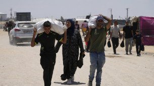 Palestinos carregando comida após chegada de ajuda humanitária