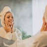 Mulher feliz ao fazer o seu skincare