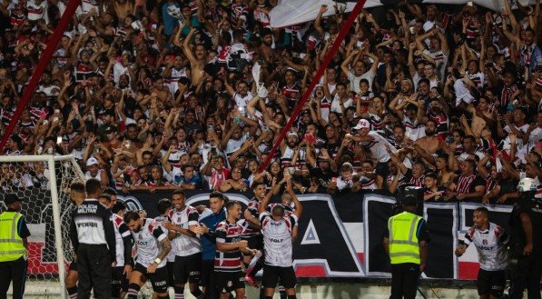 Jogadores do Santa Cruz comemorando vitória junto com a torcida