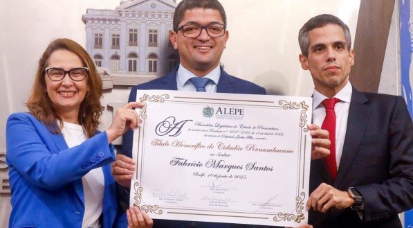 O secretário Fabrício Marques ao receber o título de Cidadão Pernambucano, ladeado pelos deputados Jarbas Vasconcelos Filho e Débora Almeida