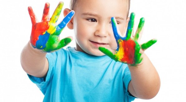 Imagem de criança com as mãos coloridas de tinta