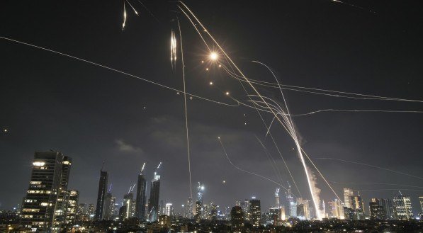 O sistema de defesa aérea israelense Iron Dome dispara para interceptar mísseis sobre Tel Aviv, Israel, sexta-feira, 13 de junho de 2025