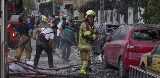 Bombeiros trabalham no local de uma explosão em um complexo residencial após Israel atacar a capital do Irã, Teerã