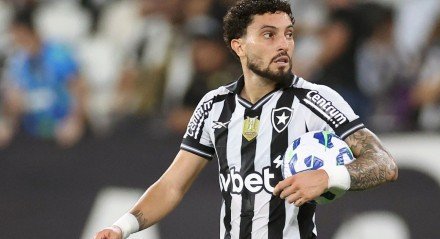 Alex Telles, lateral do Botafogo, com uma bola embaixo do braço