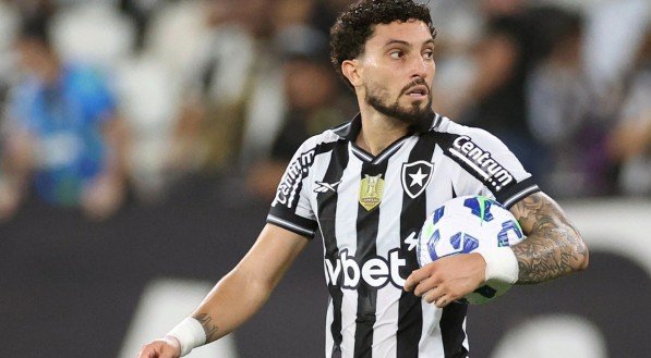 Alex Telles, lateral do Botafogo, com uma bola embaixo do braço