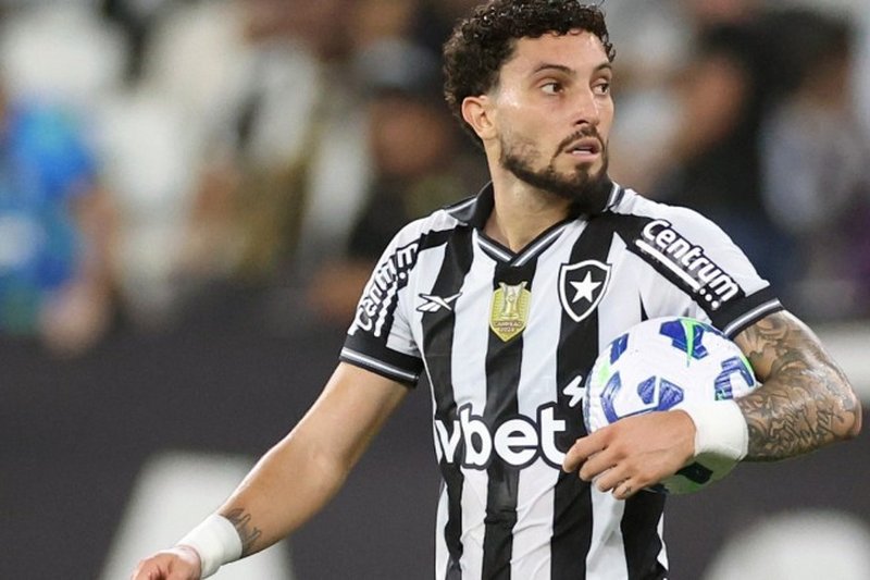 Alex Telles, lateral do Botafogo, com uma bola embaixo do braço