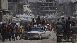 Palestinos carregam sacos de farinha saqueados de caminhões de ajuda humanitária em Khan Younis, no sul da Faixa de Gaza