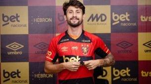 Pedro Augusto sorri e aponta para escudo do Sport