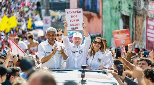 Presidente Lula segura um cartaz escrito &quot;taxa&ccedil;&atilde;o dos super ricos&quot; durante Caminhada do Dois de Julho, em Salvador, Bahia