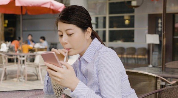 Imagem de uma mulher mexendo no celular