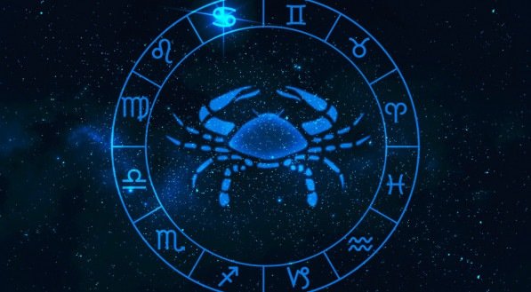 Imagem ilustrativa do símbolo de Câncer, um caranguejo, no meio de uma roda de signos, em um fundo azul estrelado