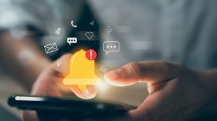 Imagem de uma mão usando smartphone mostrando o ícone de sino e notificações