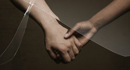 Broken relationship with cracked glass effect and people holding hands behind