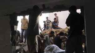 Palestinos inspecionam o local atingido por um bombardeio israelense em Muwasi, Khan Younis, na região da Faixa de Gaza