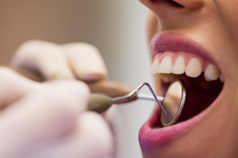 Dentista examinando a boca de um paciente