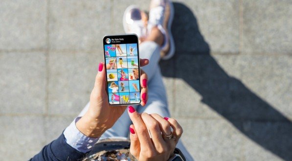 Imagem de uma mulher segurando um celular com galeria de fotos