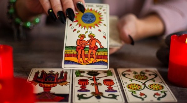 Fortune teller reading a future by tarot cards on rustic table