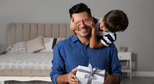 Man receiving gift for Father's Day from his son at home