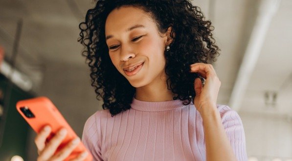 Imagem de uma mulher sorrindo para o celular