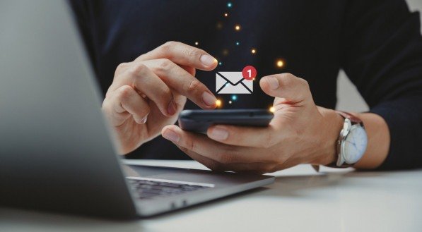 Imagem de uma mão com celular recebendo mensagem