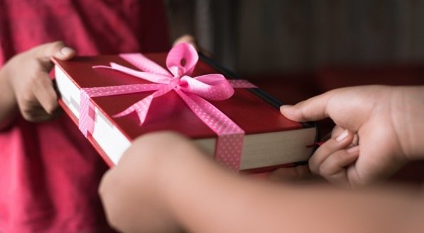 Pessoa presenteando outra com um livro