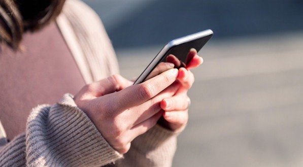 Imagem ilustrativa de uma pessoa segurando o celular!
