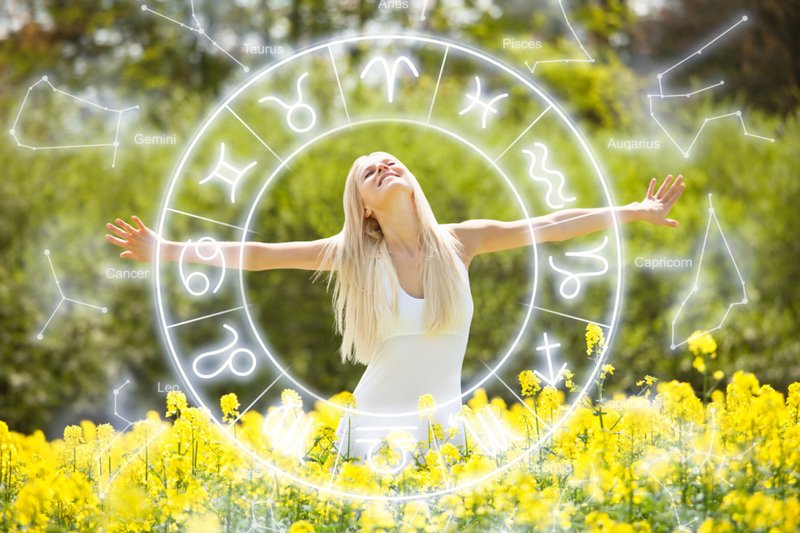Jovem mulher sorridente e relaxada em meio a flores no campo