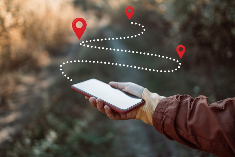 Imagem de uma mulher com um gps no celular para representar o conceito de caminho e rotas